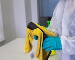 person in white robe holding black and yellow umbrella